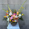 Colorful mixed flower arrangement in a round vase with tall stems