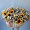 Basket of sunflowers and mixed pastel flowers with a ribbon