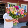 Large mixed bouquet in a glass vase with a pink ribbon