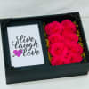 Black gift box with hot pink roses beside a card reading live laugh love
