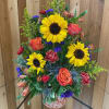 Tall mixed bouquet with sunflowers, roses, and carnations in a decorative vase