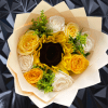 Handheld bouquet with a central sunflower surrounded by yellow and white roses in pale wrapping paper