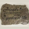Decorative stone plaque with the quote "Friends are the flowers in the garden of life"