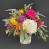 Colorful mixed bouquet in a patterned tin container