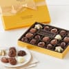 Box of assorted chocolates with a yellow gift box and ribbon