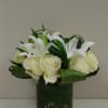 White roses and lilies arranged in a glass vase