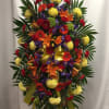 Large standing spray with mixed bright flowers and a yellow ribbon