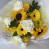 Bouquet of yellow sunflowers and white roses wrapped in white paper