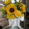 Yellow sunflower and rose bouquet in a white vase with a white ribbon