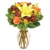 Yellow lily bouquet with orange and red flowers in a clear glass vase