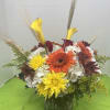 Mixed bouquet with calla lilies, gerbera daisies, and chrysanthemums in a glass vase