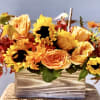 Autumn bouquet of yellow sunflowers and orange roses in a striped vase