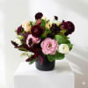 Mixed bouquet in a black vase with pink, white, and burgundy blooms