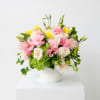 Pink and white roses with yellow blooms in a white vase