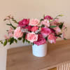Pink and blush roses arranged in a white vase