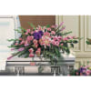 Large pink and purple floral spray on a silver casket