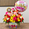 Birthday flower arrangement with roses, daisies, and balloons in a gift box
