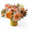 Peach and white mixed bouquet in a yellow wrapped vase