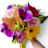 Beautiful and colorful hand held wrapped bouquet with long flowing ribbons and