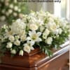 White floral casket spray with lilies and roses