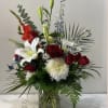 Mixed bouquet of red roses, white lilies, and white chrysanthemums in a glass vase