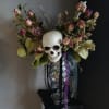Skull centerpiece with pink roses and ribbons in a clear vase