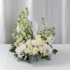 White floral arrangement with roses and a small angel figurine