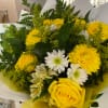 Yellow roses and white daisies in a wrapped bouquet