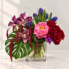 Mixed bouquet in a clear glass vase with red roses and pink blooms