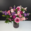 Pink and purple mixed bouquet in a textured glass vase