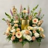Large floral arrangement with peach roses, white blooms, and a gold vase centerpiece