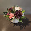 Artificial floral arrangement in a white pumpkin-shaped container
