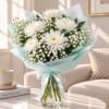 White chrysanthemum bouquet in a glass vase with pale blue wrap