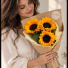 Woman holding a bouquet of sunflowers wrapped in brown paper