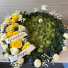Heart-shaped floral tribute with yellow and white roses and a golf-themed center
