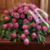 Pink rose arrangement with ribbon on a wooden surface