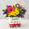 Bright mixed flower arrangement in a birthday gift box with a ribbon