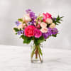 Bouquet of pink and purple roses in a clear glass vase