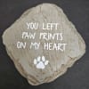 Decorative stone with the words "You left paw prints on my heart" and a paw print