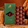 Chocolate bar and green gift box on wooden slices