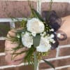 White rose wrist corsage with black ribbon and greenery