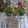 Flower bar display with mixed bouquets in white metal buckets