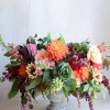 Large mixed flower arrangement in a stone pedestal vase