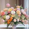 Large pastel rose arrangement in a white vase