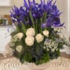 Purple iris arrangement with white blooms in a low glass bowl