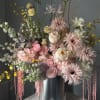 Tall pastel floral arrangement in a silver cylinder vase