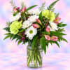 Mixed bouquet of white daisies, pink lilies, and green carnations in a glass jar vase