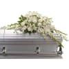 White floral spray arranged on a silver casket