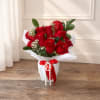 Bouquet of red roses in white wrapping with a red ribbon