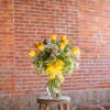 Yellow rose bouquet in a clear glass vase with a yellow ribbon
